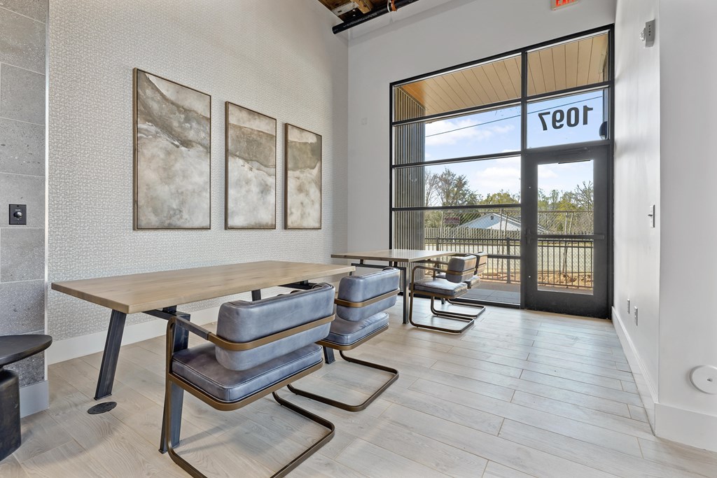 A modern dining room with a wooden table and grey chairs.