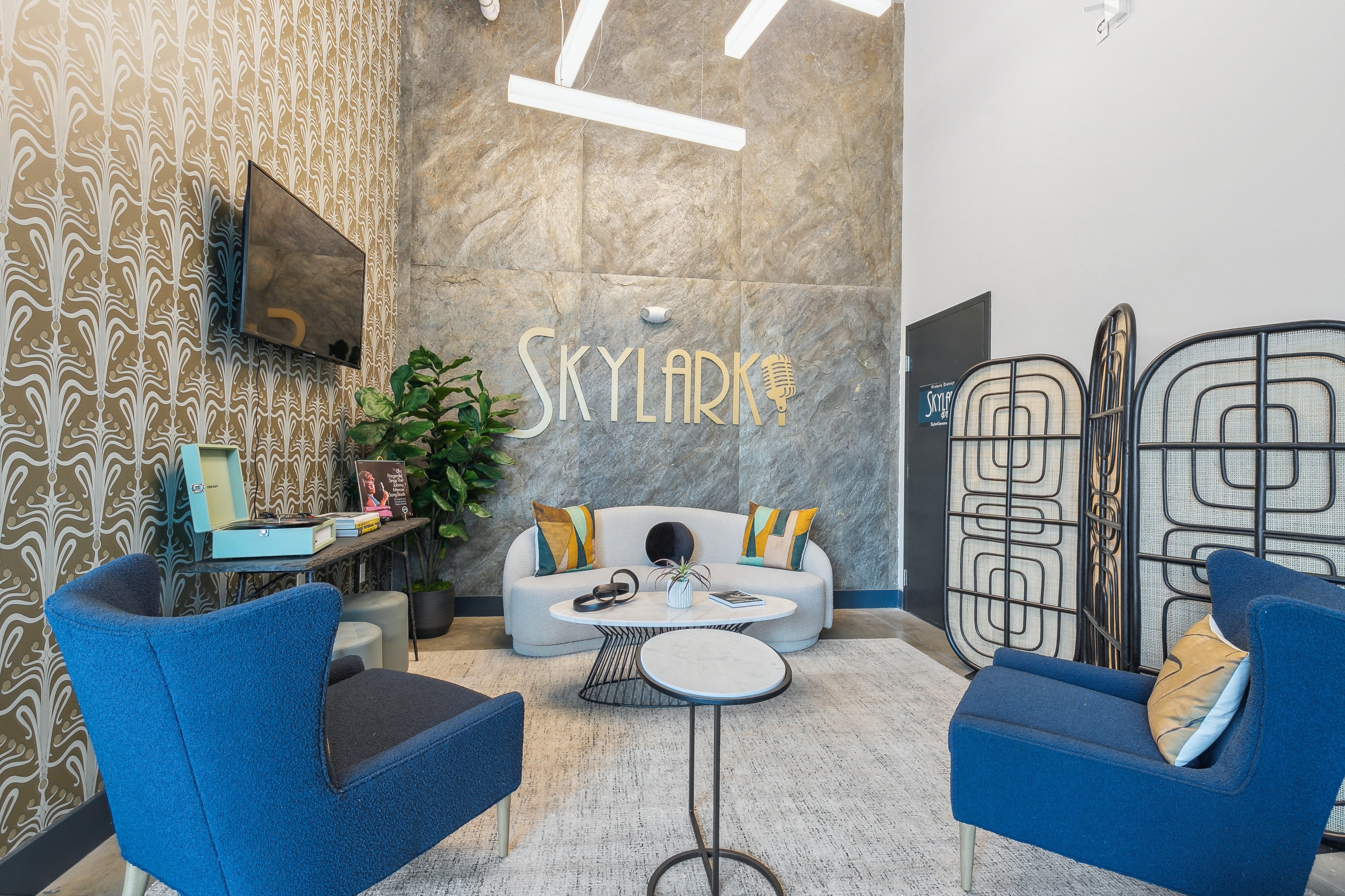 a living room with blue furniture and a sign on the wall