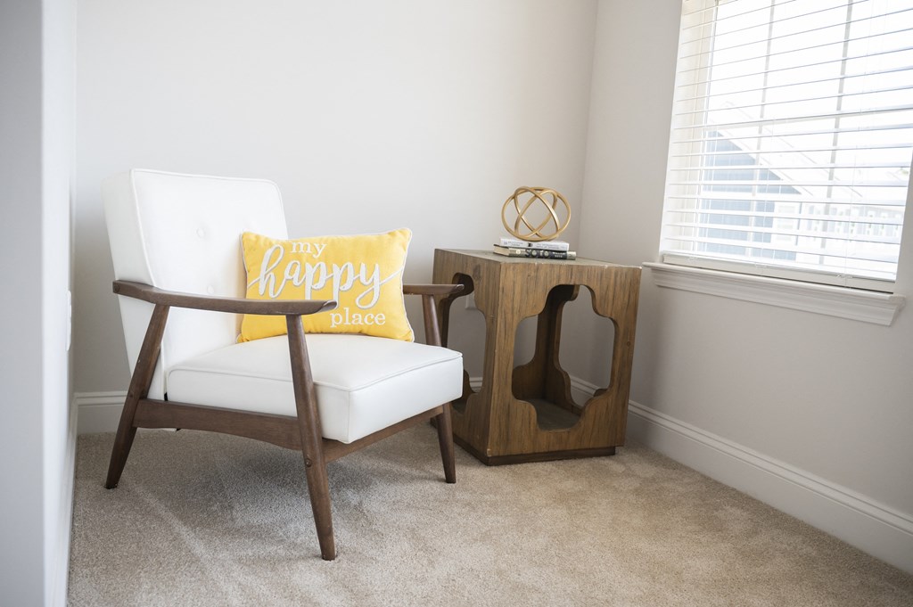 a room with a chair and a side table with a pillow on it at Landon Green Artisan Cottages Apartments, North Carolina