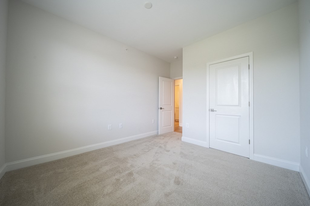 a bedroom with white walls and carpet at Landon Green Artisan Cottages Apartments, Hickory, North Carolina