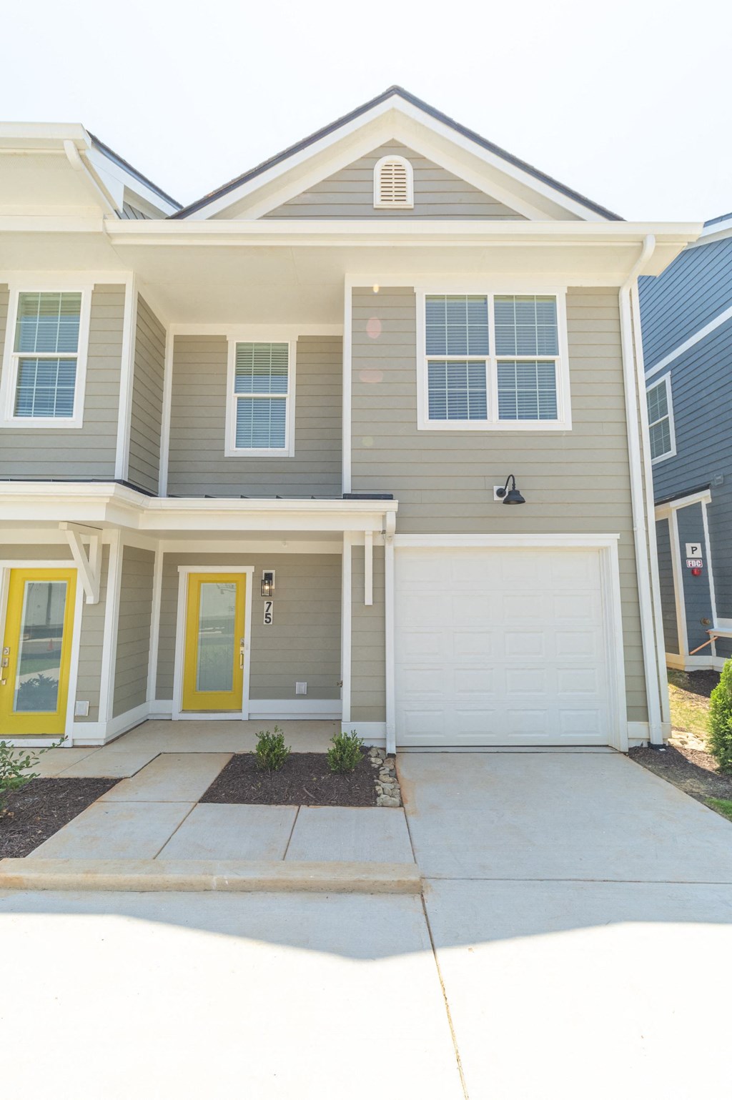 a house with a yellow door and gray siding at Landon Green Artisan Cottages Apartments, North Carolina