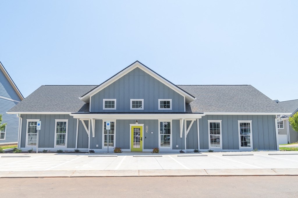 a blue house with a gray roof and a yellow door at Landon Green Artisan Cottages Apartments, Hickory, North Carolina