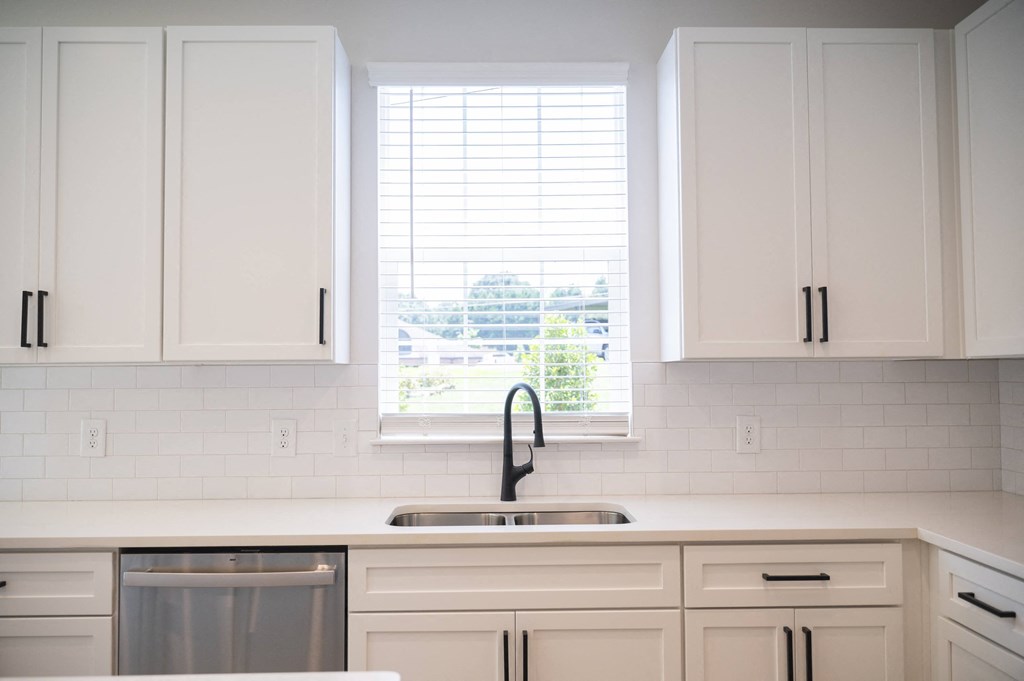 a kitchen with white cabinets and a large window at Landon Green Artisan Cottages Apartments, Hickory