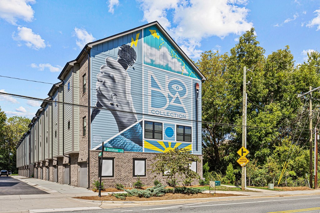 A mural on the side of a building with a man holding a hammer and a sign that says College.