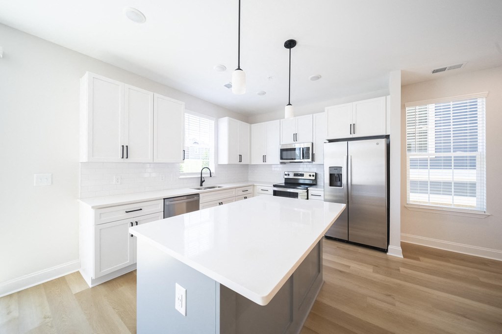 a kitchen with white cabinets and a large island at Landon Green Artisan Cottages Apartments, Hickory, North Carolina
