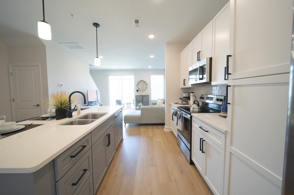 a kitchen with white cabinets and stainless steel appliances at Landon Green Artisan Cottages Apartments, North Carolina, 28601