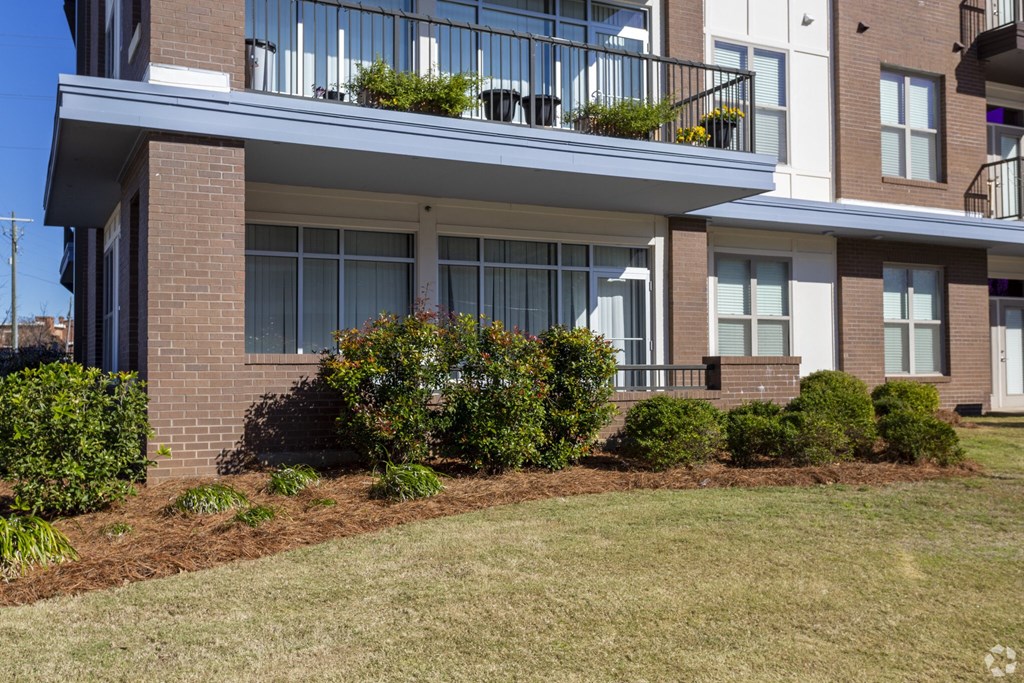 the front of a house with a yard and a balcony
