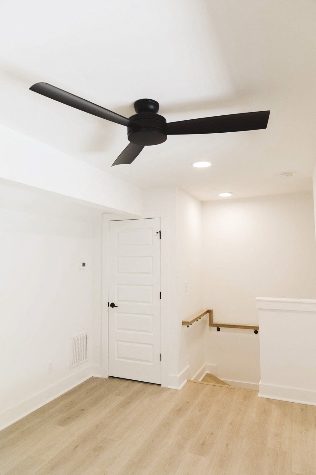 a living room with a ceiling fan and a staircase