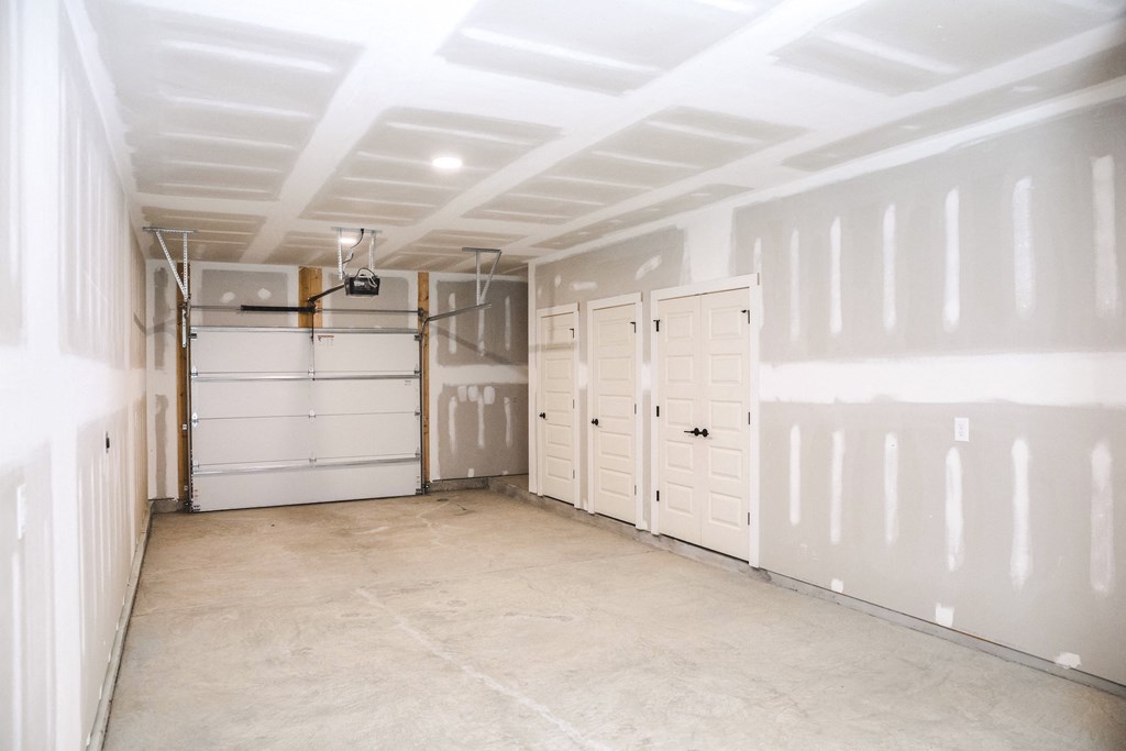 a garage with white walls and a row of white closets