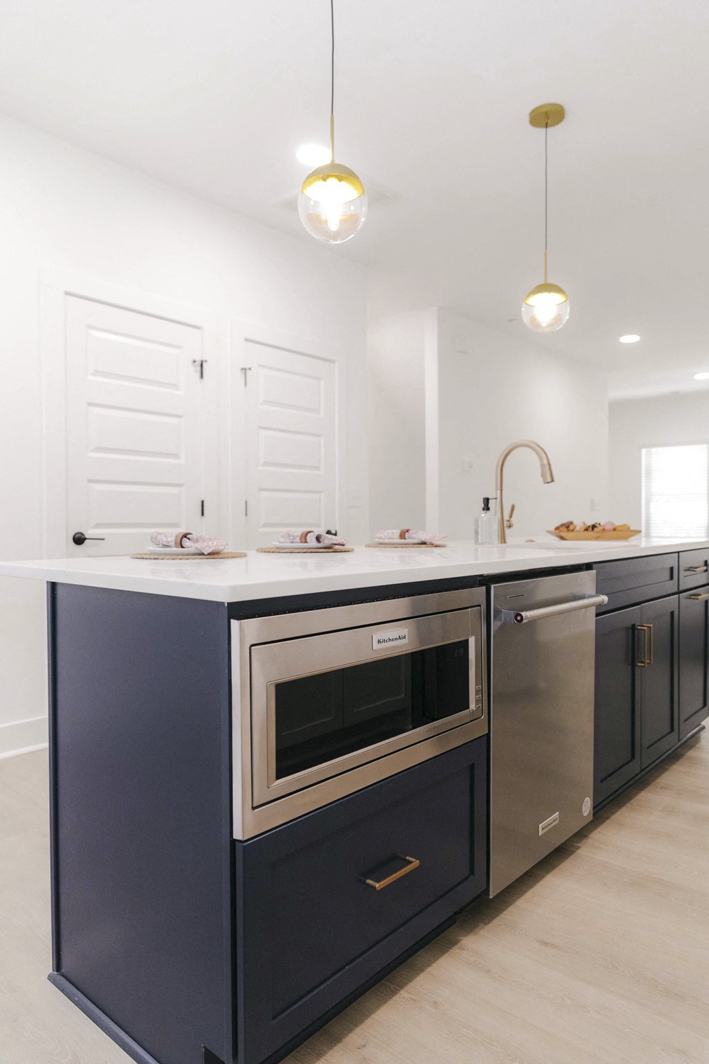 a modern kitchen with a blue island and stainless steel appliances
