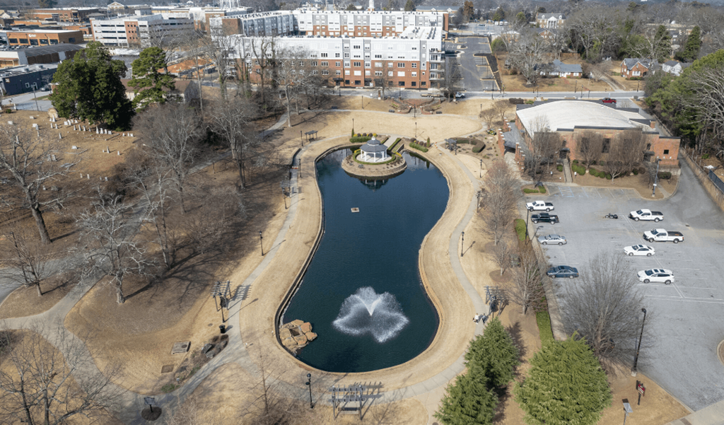 an aerial view of a lake in a park with a fountain at Park View Greer, South Carolina