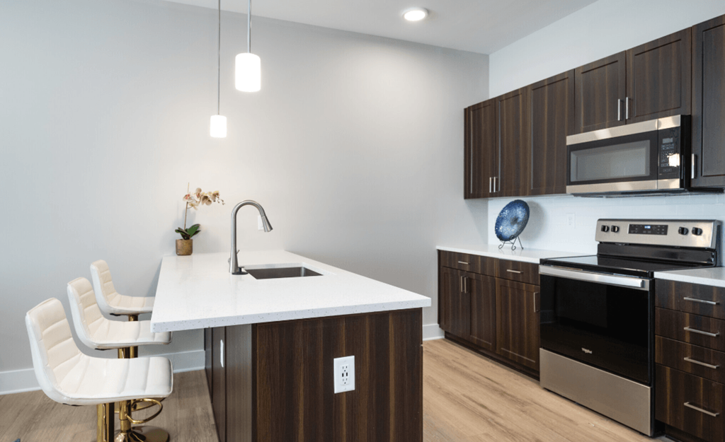 a kitchen with a white counter top and wooden cabinets at Park View Greer, Greer