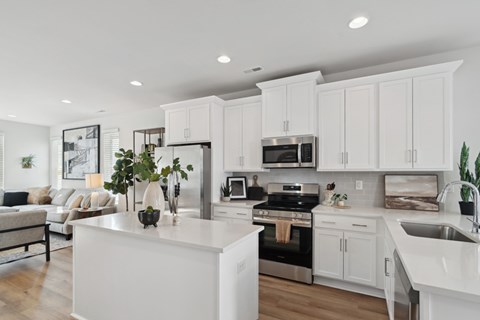 A modern kitchen with white cabinets and stainless steel appliances.