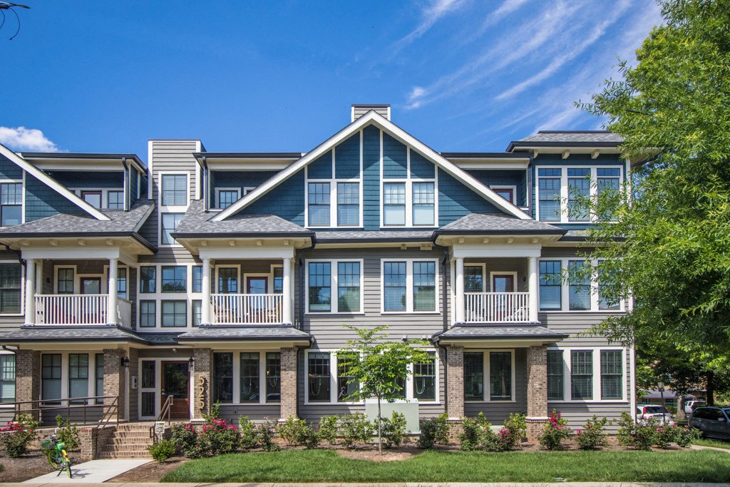 A row of houses with a blue sky in the background.