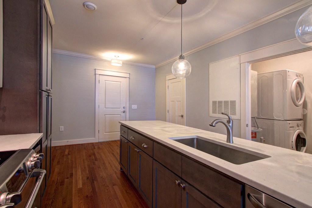 A kitchen with a sink and a washing machine.