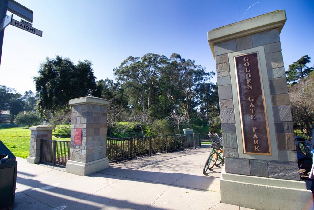 a man riding a bike down a sidewalk next to a sign