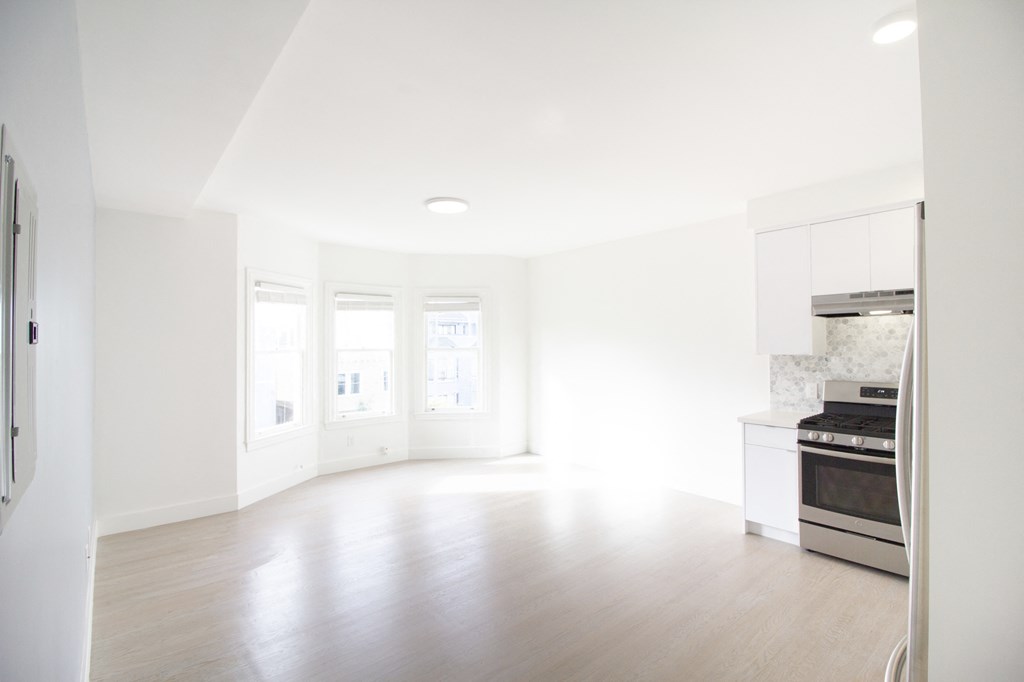 Open-concept living room and kitchen area with upgraded appliances.