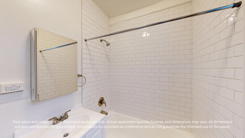 A white tiled bathroom with a shower and a towel rack.