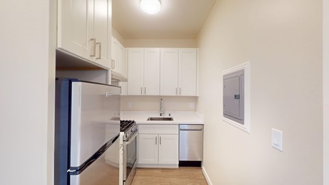 A kitchen with white cabinets and appliances.