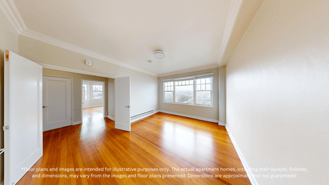 A spacious room with wooden floors and white walls.