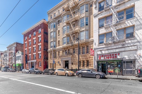 A street view with cars parked and buildings on the side.