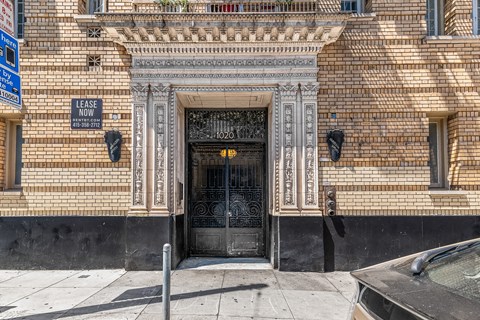 A building with a black door and a sign that says "LEASE NOW".