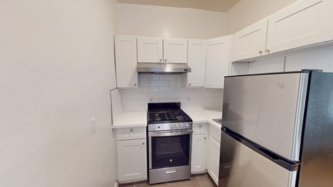 A kitchen with white cabinets and stainless steel appliances.