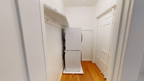 A white refrigerator in a narrow hallway.