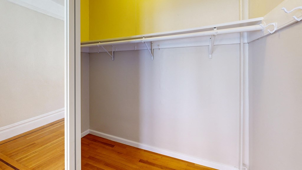 an empty bedroom with a sliding closet door and wood floors