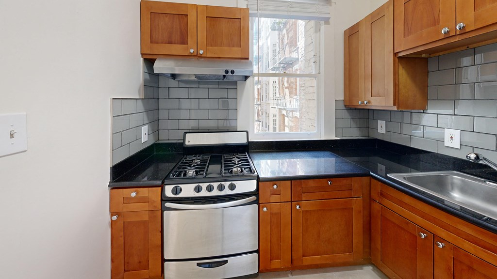 an empty kitchen with a stove and a window
