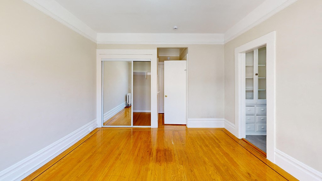 a living room with a hard wood floor and white walls