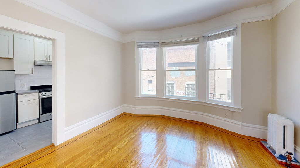 a living room with a wood floor and three windows
