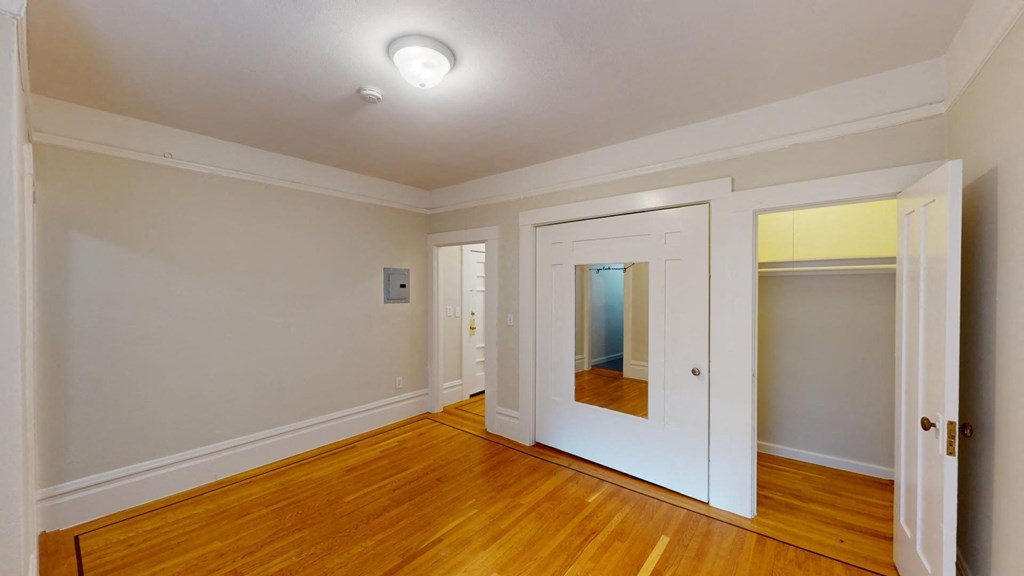 a living room with wood floors and a door to a closet