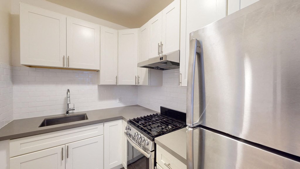 a white kitchen with stainless steel appliances and white cabinets