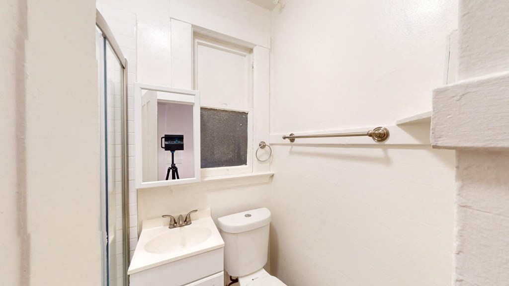 a bathroom with a toilet sink and a mirror
