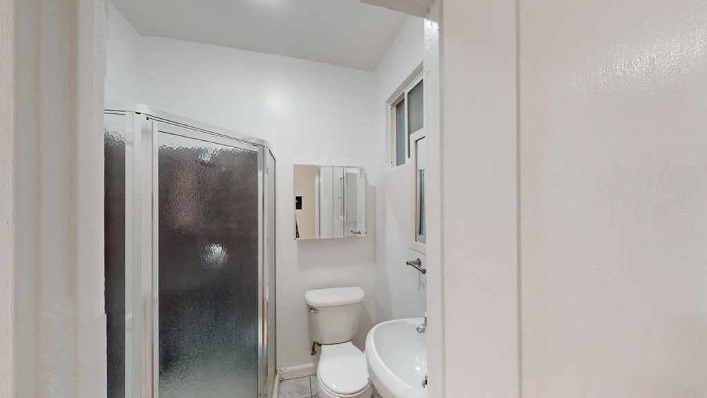 a bathroom with a shower toilet and sink