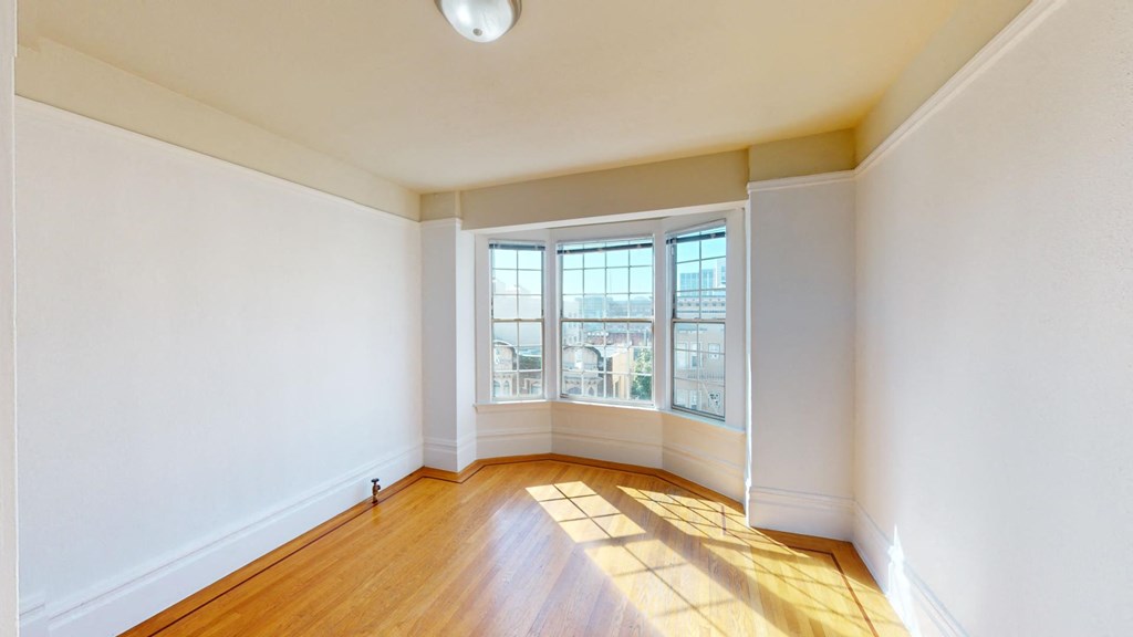 an empty living room with white walls and a window