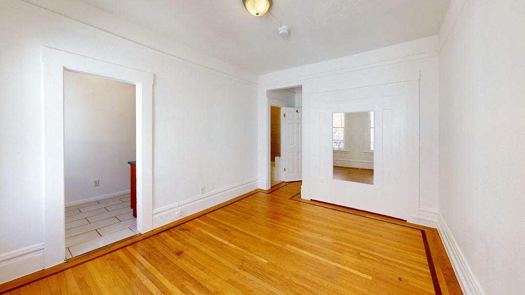 a living room with wood floors and white walls