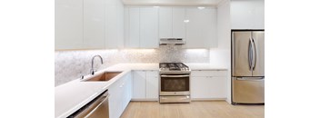large kitchen with stainless steel appliances and white cabinets