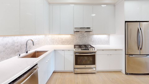 large kitchen with stainless steel appliances and white cabinets