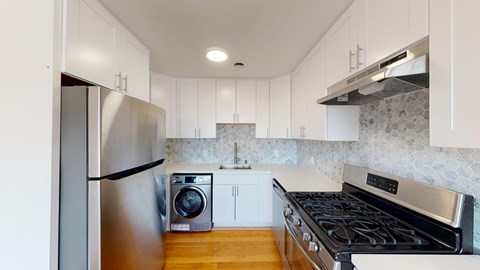 A modern kitchen with a stainless steel refrigerator and a stove top oven.