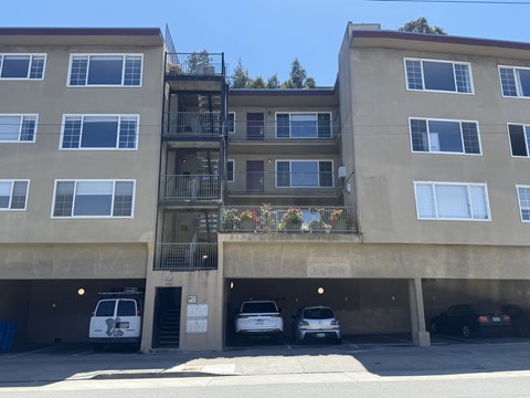 A building with a balcony and a parking garage.