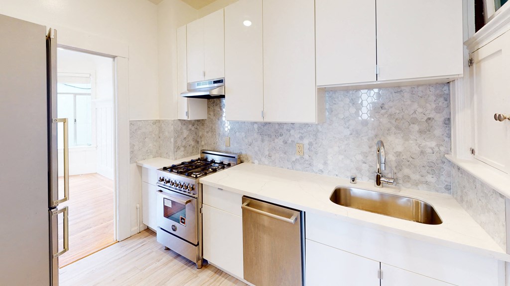 Kitchen with upgraded stainless steel appliances and white cupboards.