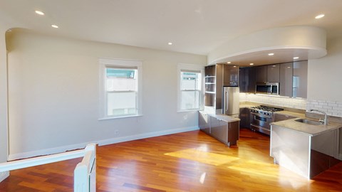 a kitchen with a wooden floor and stainless steel appliances