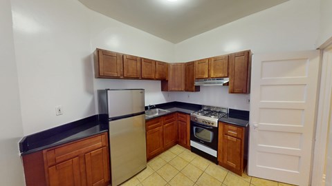 A kitchen with wooden cabinets and black countertops.