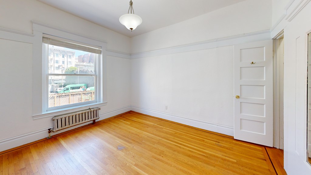 A room with wooden floors and white walls.