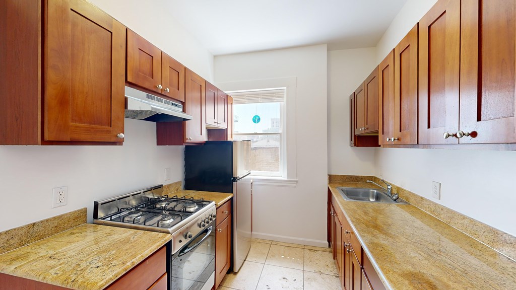 A kitchen with wooden cabinets and a granite countertop.