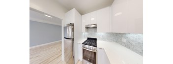 a renovated kitchen with white cabinets and stainless steel appliances
