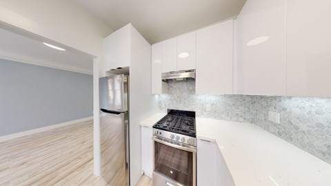 a renovated kitchen with white cabinets and stainless steel appliances
