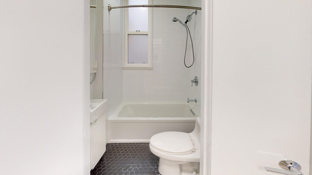 a small white bathroom with a toilet and a shower